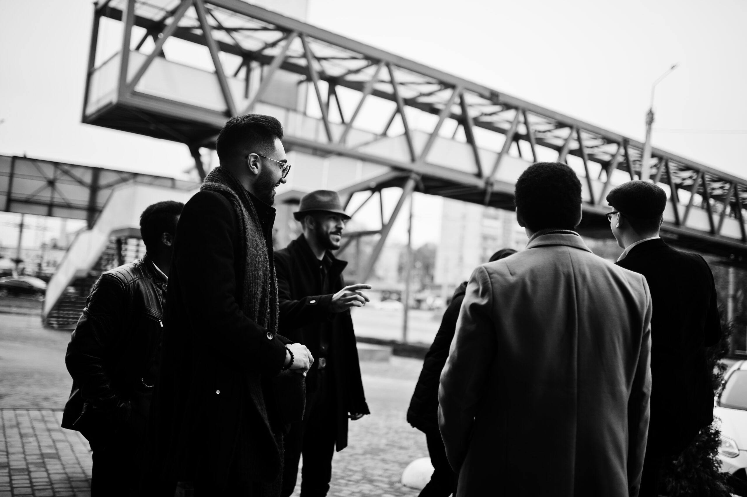 Group of handsome retro well-dressed man gangsters smoking outdoor. Multiethnic male bachelor mafia party.